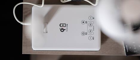 A white electronic device with a USB port and power buttons on a wooden surface.