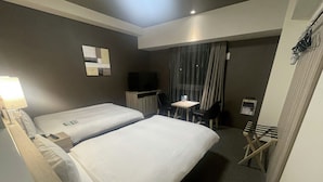 A hotel room with two beds, a desk with a chair, a television, and a small table. - Route Inn Grantia Tokai Spa & Relaxation (Tokai)