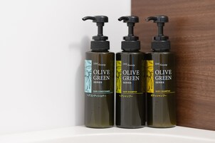 Tres botellas de acondicionador para cabello verde oliva, champú para cabello y jabón corporal.