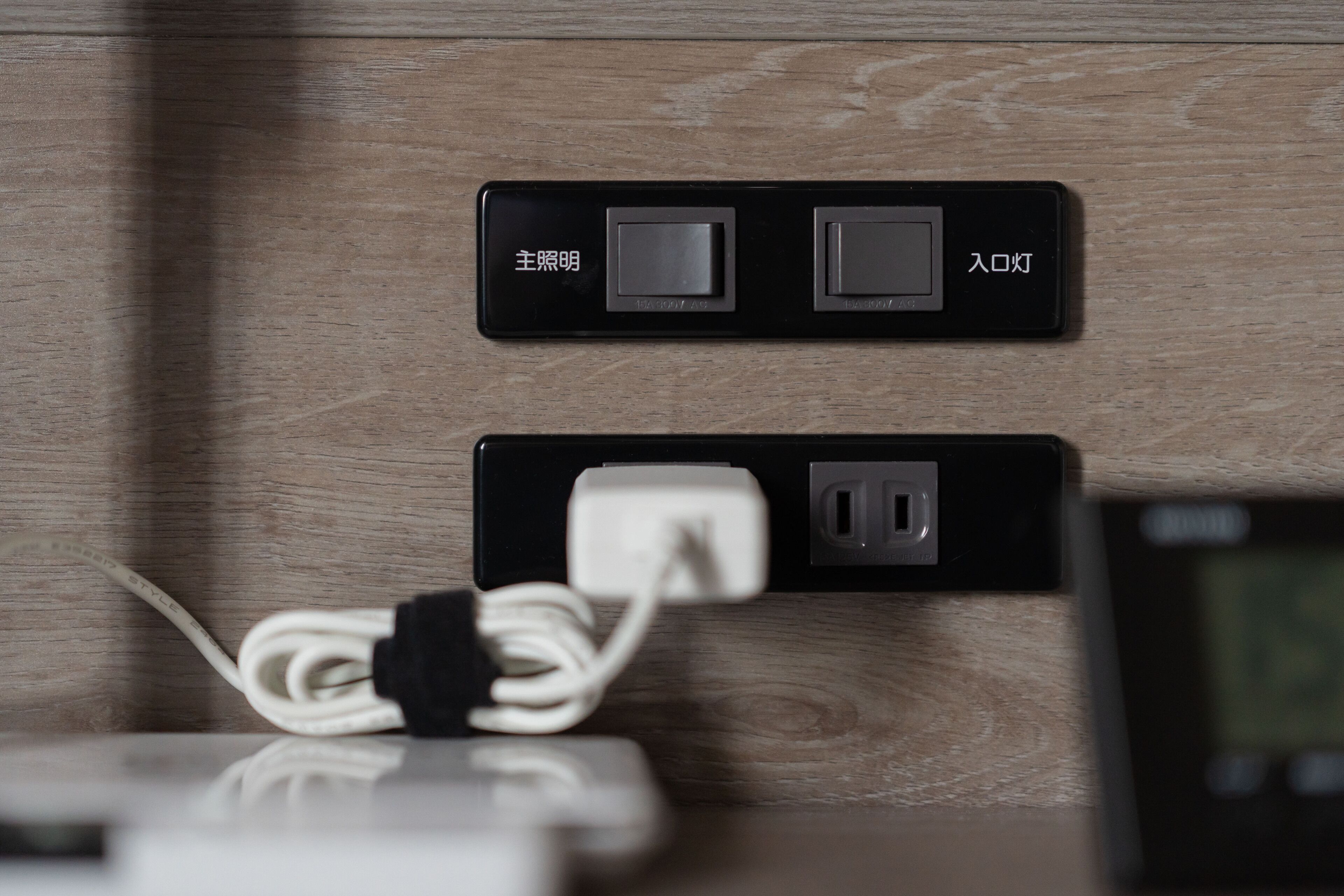 A wall-mounted power strip with two sockets and a cable plugged in.