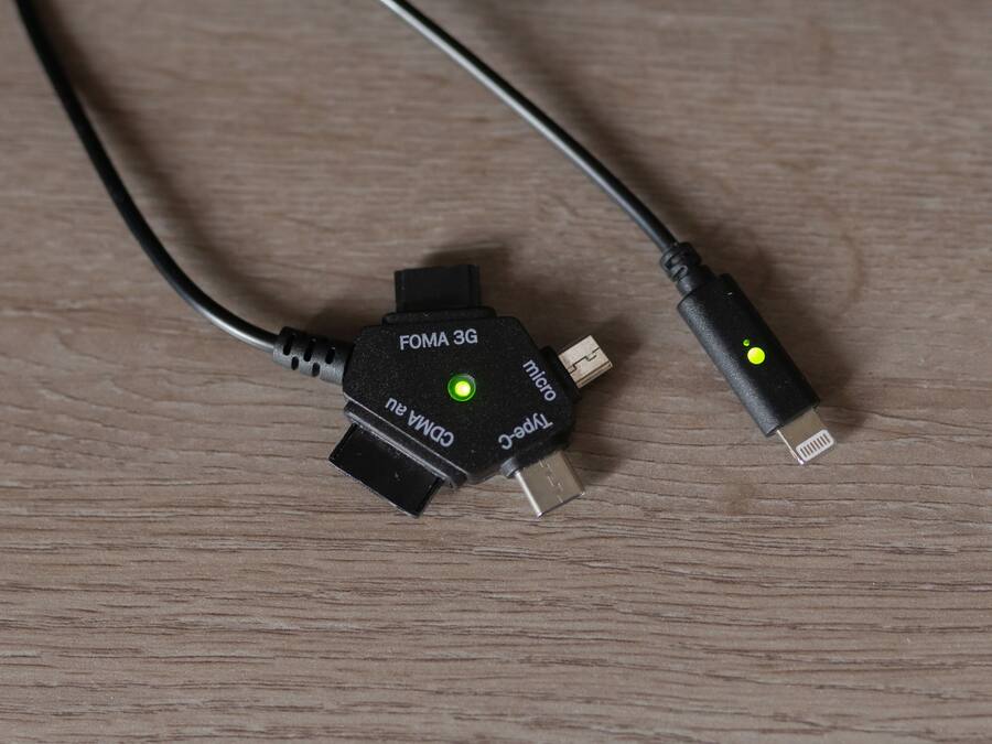 Ein FOMA 3G-Modem mit USB-Kabel auf einer Holztischfläche.