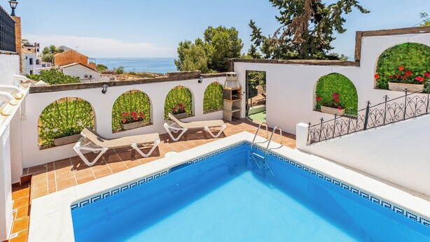 A rooftop pool with a clear view of the sea, surrounded by white walls with arched windows and potted plants. - La Piriposa Vélez-Málaga by Ruralidays (Málaga)