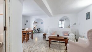 A spacious living area with a dining table, a sofa, and a coffee table. - La Piriposa Vélez-Málaga by Ruralidays (Málaga)
