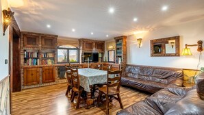 Ein gemütliches Wohnzimmer mit Essbereich, Holzmöbeln und einem Kamin.