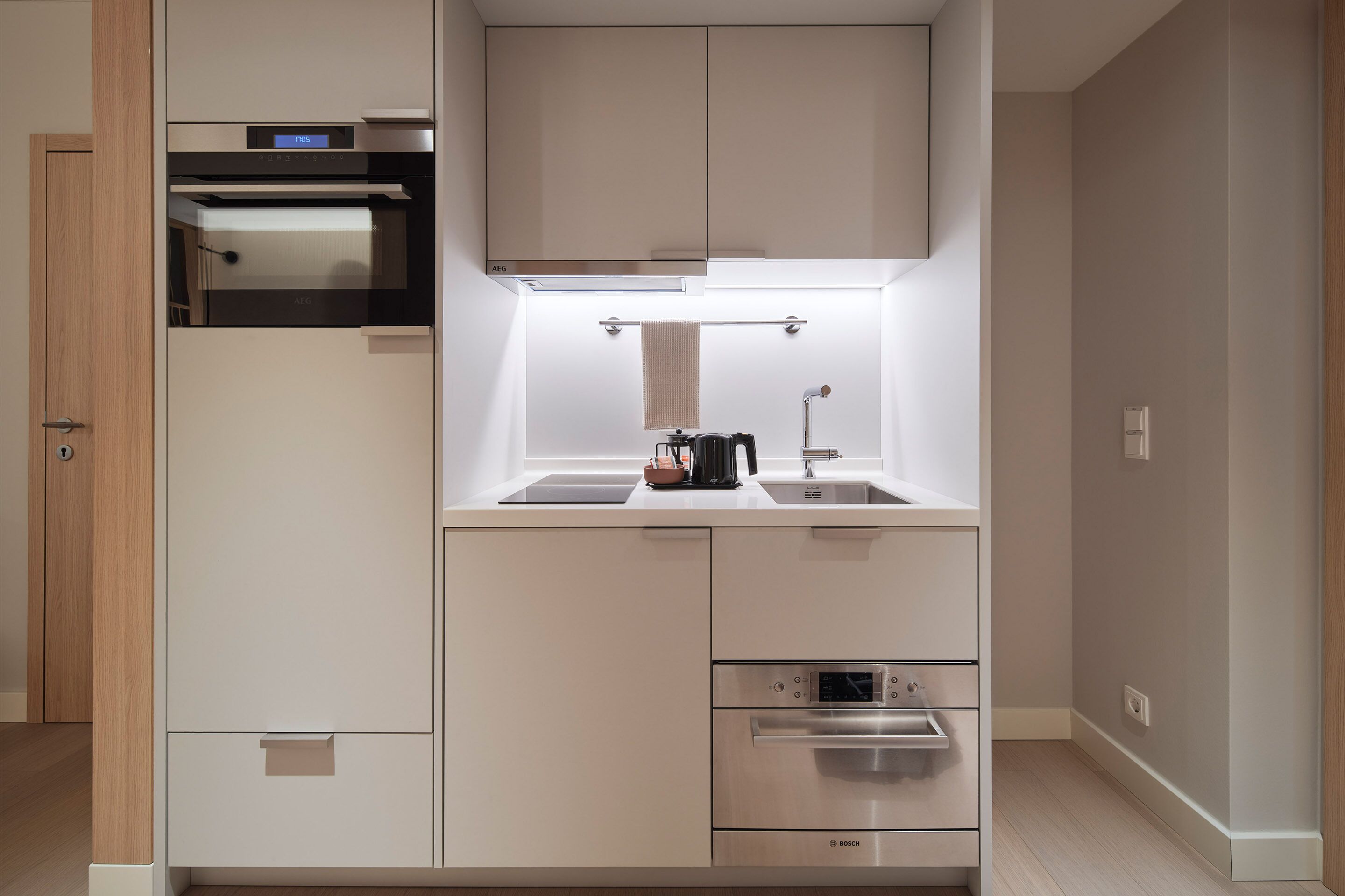 Eine moderne Küche mit eingebauten Geräten, einem Edelstahlbackofen und einem Spülbecken.