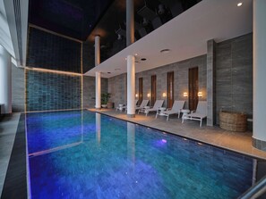 Una piscina cubierta, tumbonas