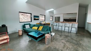 A modern living room with a sofa, coffee table, and bar area. - New Modern Home on Sylvan Lake Road (Custer)