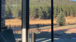 A room with large windows offering a view of a mountainous landscape. - New Modern Home on Sylvan Lake Road (Custer)
