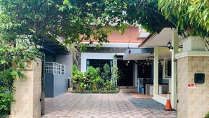A gated entrance with a paved driveway leading to a building. - Baan Barrier (Pattaya)