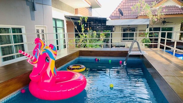 A swimming pool with a pink unicorn float and a ladder. - Baan Barrier (Pattaya)