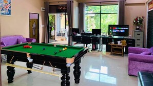 A room with a pool table, purple sofas, a desk with computers, and a TV. - Baan Barrier (Pattaya)