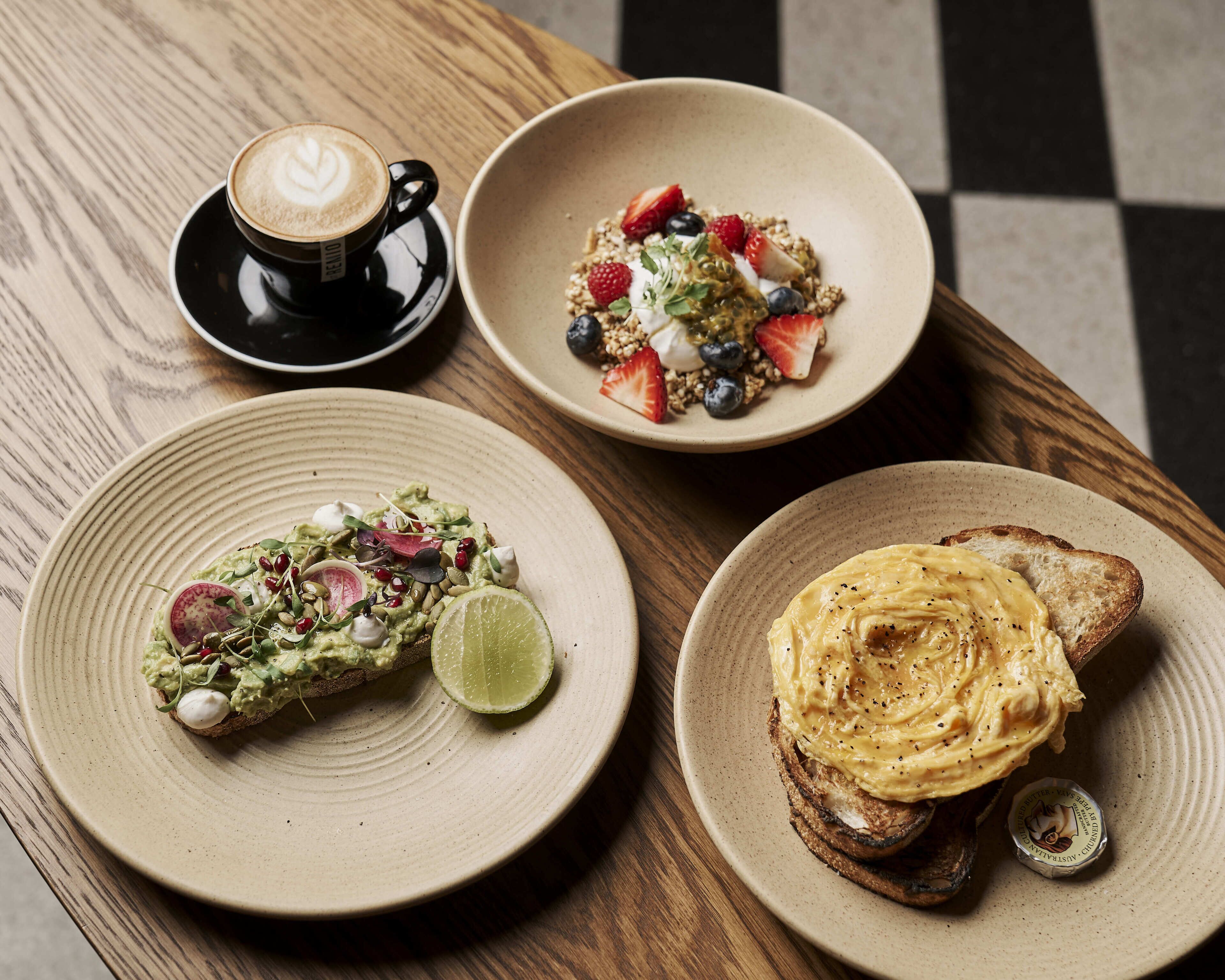 Three plates of food on a wooden table.
