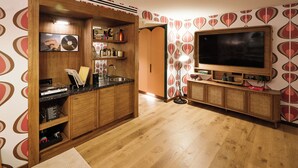 Een keuken met houten kasten, een ingebouwde televisie en een behang met een patroon.