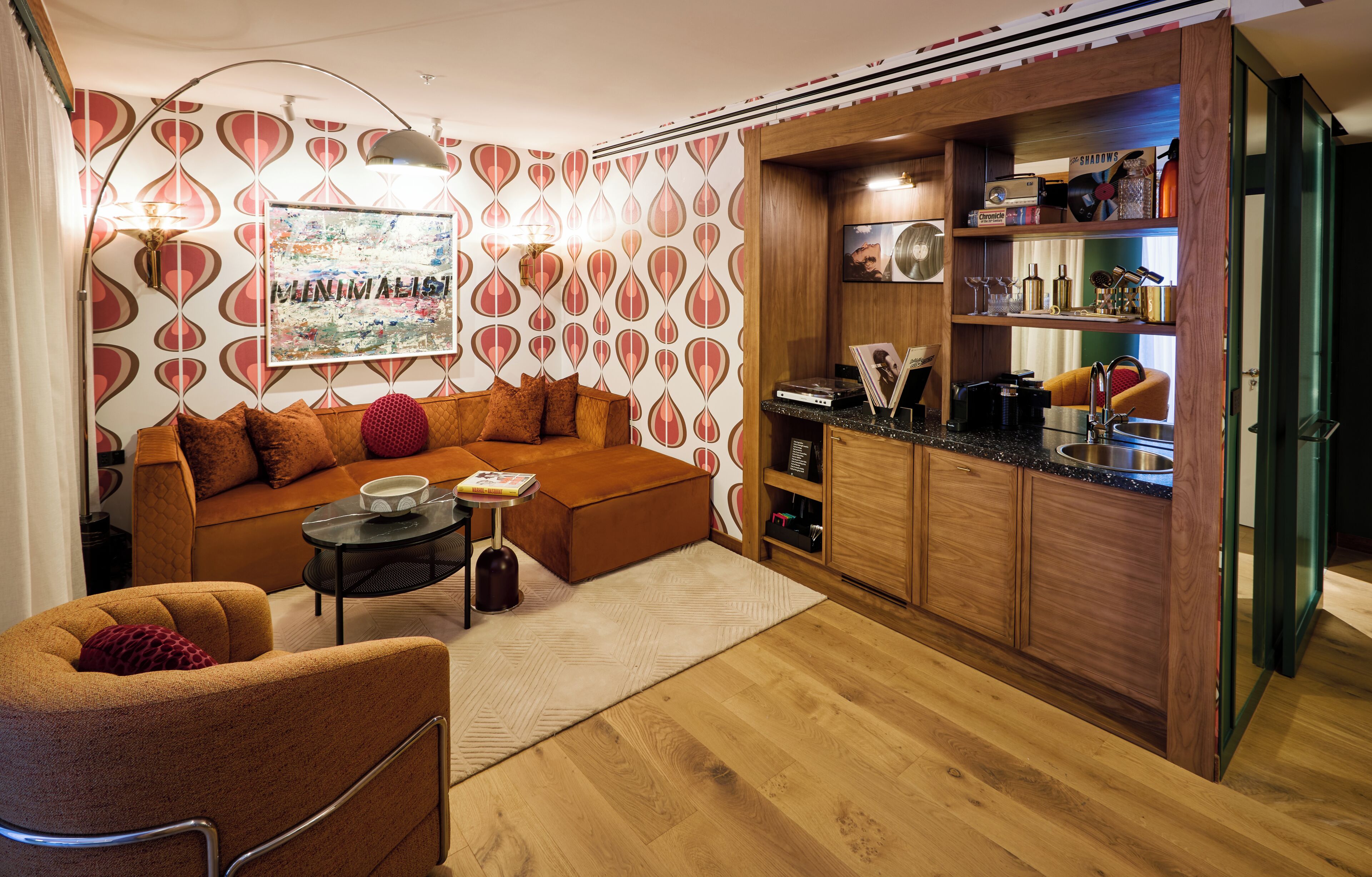 A compact living space with a sofa, a small coffee table, and a kitchenette area with wooden cabinets and a countertop.