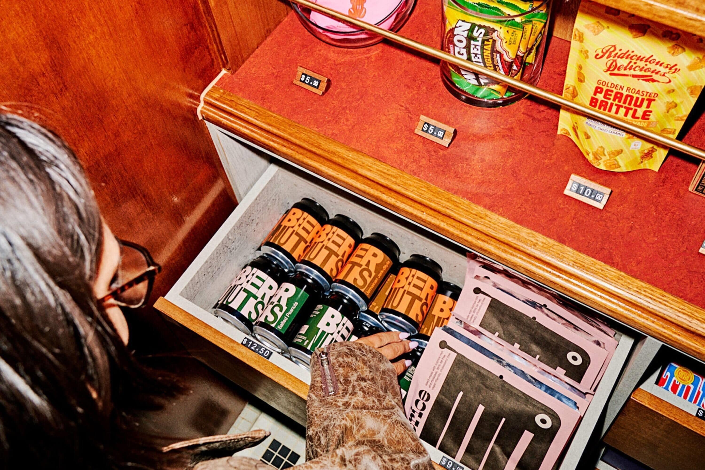 A vintage-style refrigerator stocked with various food items, including jars of pickles and a bag of chips.