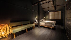 A dimly lit room with a bed, a bench, and a wall-mounted shelf. - Sanjusangendo Yoinotake (Kyoto)