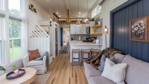 Una cocina moderna con una isla central, taburetes de madera e iluminación colgante.