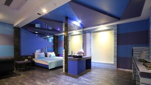 A modern hotel room with a bed, seating area, and a small kitchenette. - Hotel Lesign (Busan)