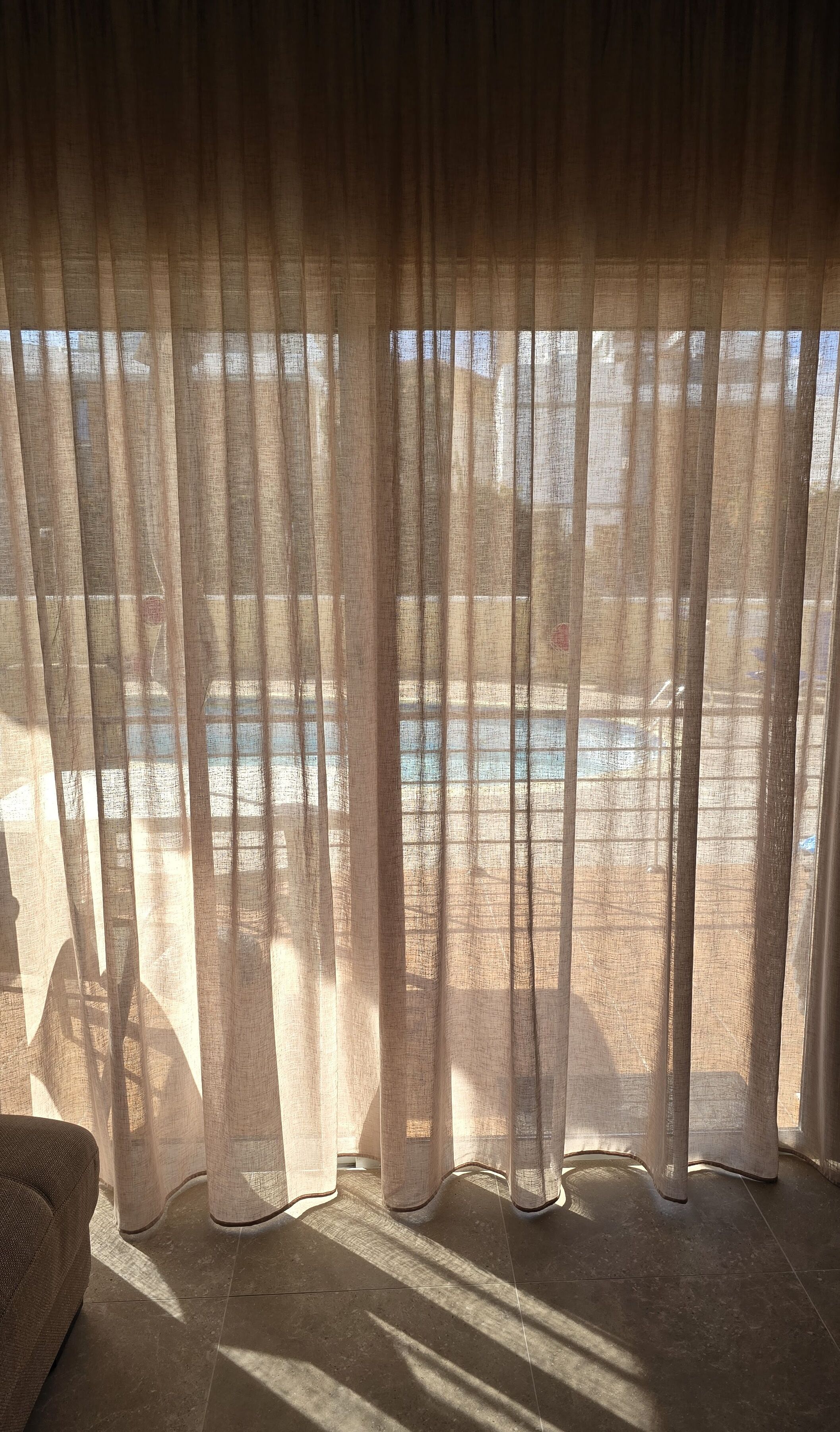 A room with a view of a pool and a chair.