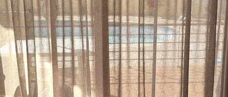 A room with a view of a pool and a chair.