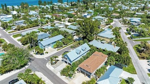 An aerial view of a residential area with houses, roads, and a coastline.