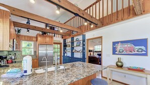 A kitchen with granite countertops, wooden cabinets, and a stainless steel refrigerator.