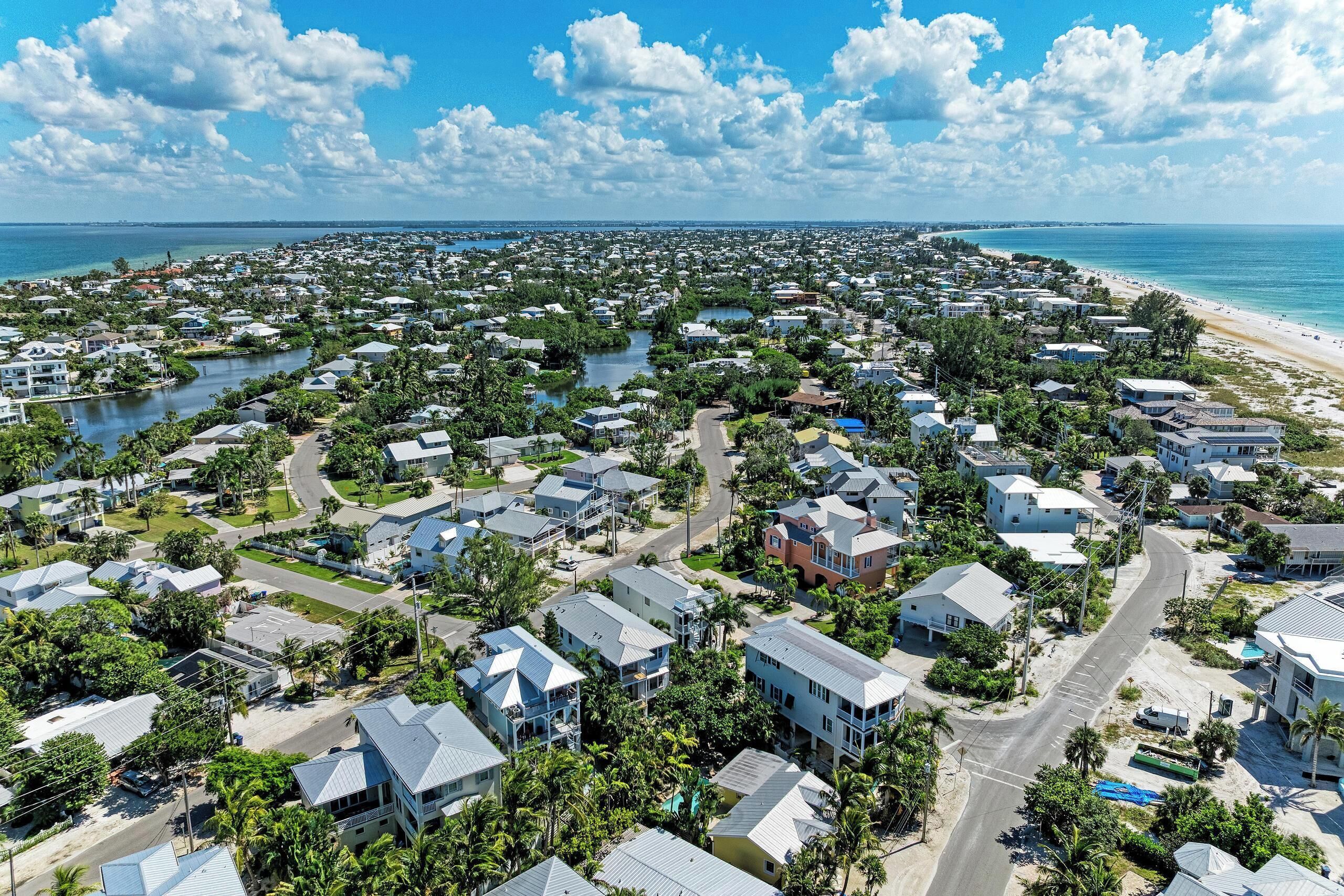 A coastal residential area with houses, roads, and a beach.