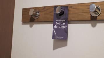 Ein Holzpaneel mit zwei Türgriffen und einem Schild mit der Aufschrift 'S'il vous plaît Ne pas déranger HOMEWOOD SUITES'.