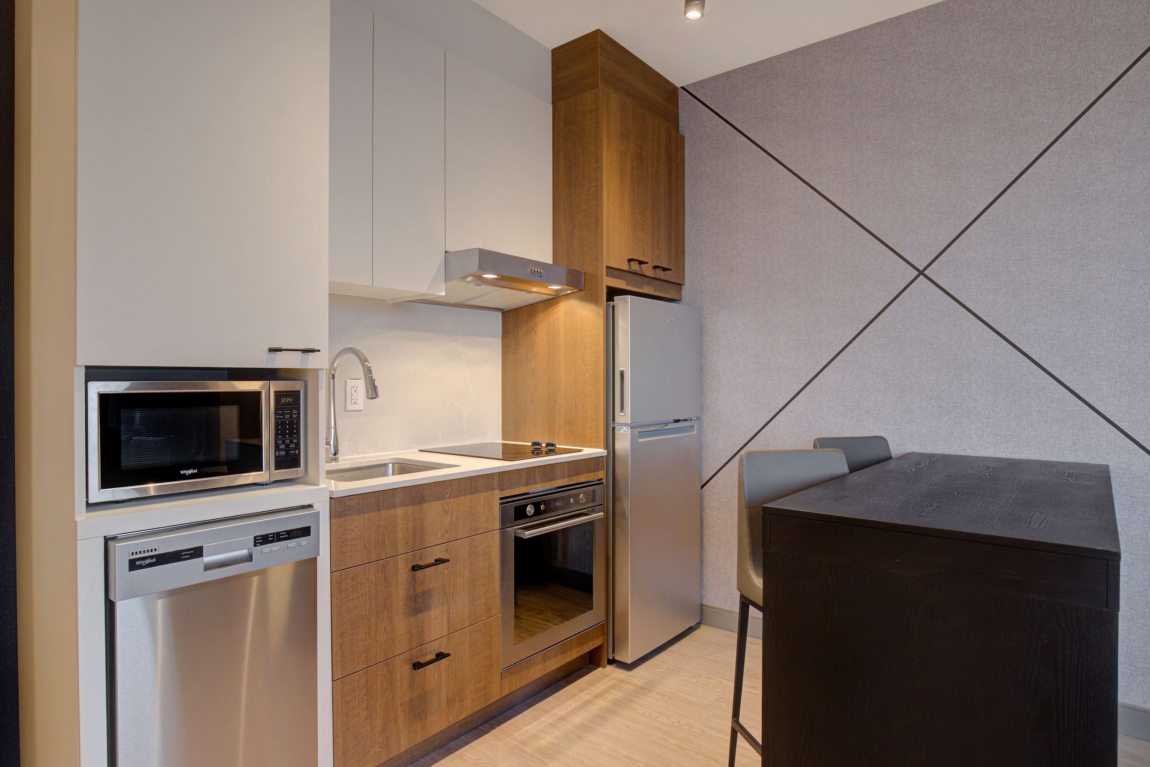 A compact kitchen with a microwave, oven, dishwasher, and refrigerator.