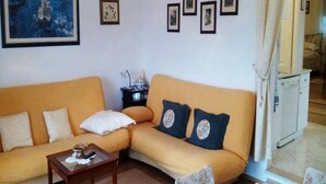 A living room with a sofa, a coffee table, and a painting on the wall. - Apartment Agata (Supetar)