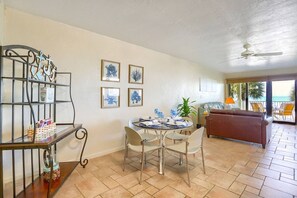 Ein Essbereich mit einem runden Tisch und Stühlen, einem Metallregal mit Dekoration und gerahmten Kunstwerken an der Wand.