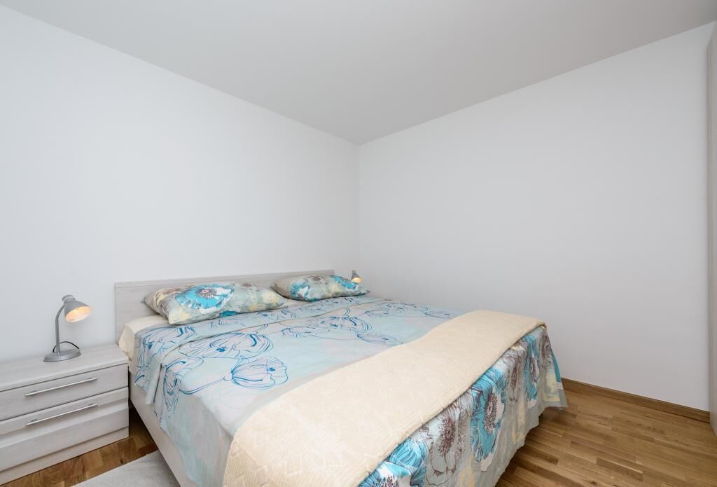 Ein Schlafzimmer mit Bett, Nachttisch und einer Schreibtischlampe.