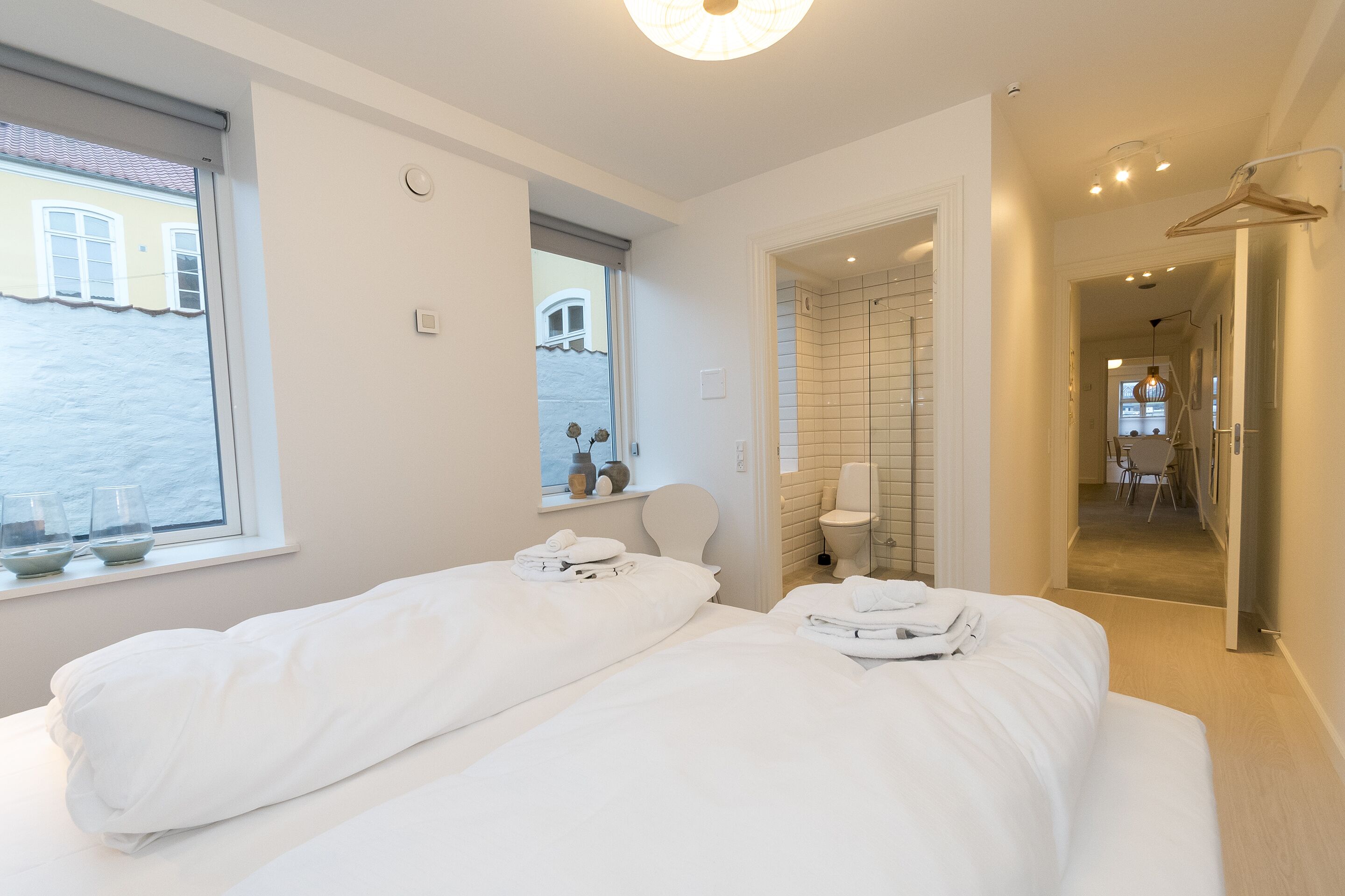 Una moderna camera d'albergo con due letti, un bagno e vista mare.