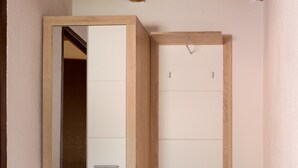 A room with a wooden wardrobe, a bench, and a tiled floor. - Holiday home Veki (Korenica)