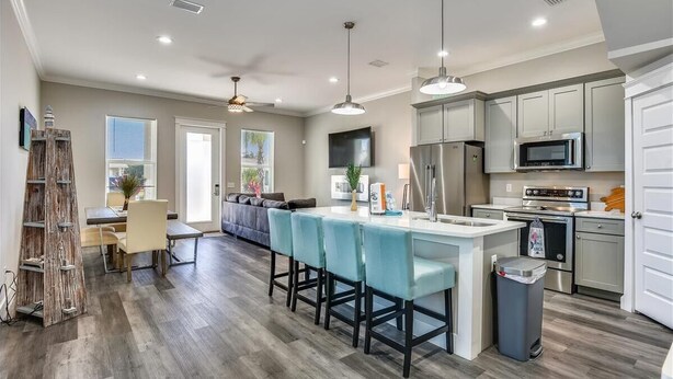 A modern kitchen with a central island, stainless steel appliances, and pendant lighting. - Home with rooftop beach views, winter open, snowbirds welcome! (Panama City Beach)