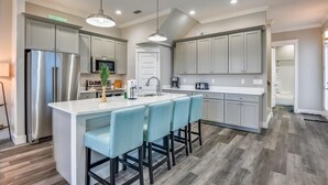 A modern kitchen with a central island, stainless steel appliances, and light grey cabinetry. - Home with rooftop beach views, winter open, snowbirds welcome! (Panama City Beach)