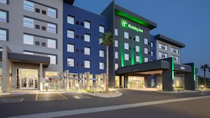 A Holiday Inn hotel with a modern facade, multiple floors, and a well-lit entrance.