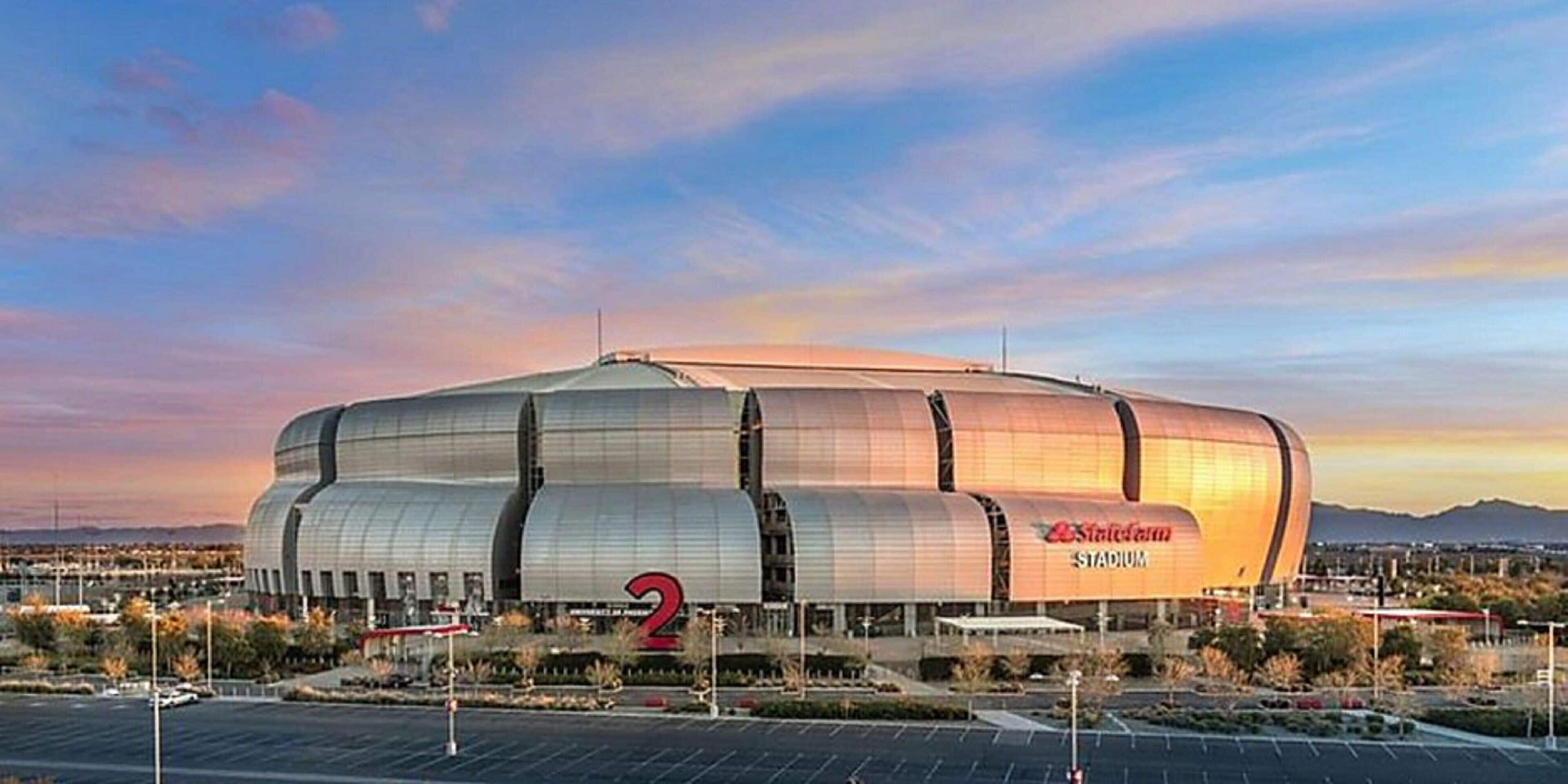 Ein großes Stadion mit einer auffälligen Beschilderung mit der Nummer 2, umgeben von Parkplätzen und blauem Himmel.