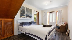 Ein Schlafzimmer mit einem Bett, einem Sessel und einem Bild an der Wand.