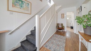 Eine Treppe mit Geländer, einem gemusterten Teppich und einem Blumentopf.