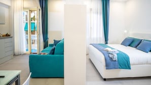Quarto de hotel moderno com cama, sofá e escrivaninha.