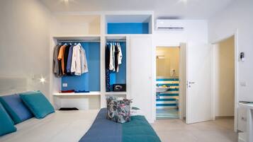 A modern bedroom with a bed, a wardrobe, and a bathroom visible through an open door.