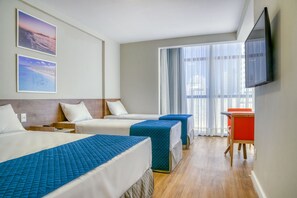 A hotel room with two beds, a TV, and a balcony with curtains. - Verano Pajucara By Tropicalis (Maceió)