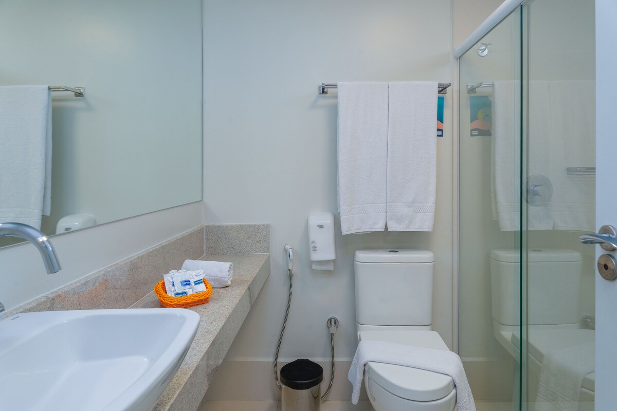 Une salle de bain moderne avec un lavabo, des toilettes et une douche à parois de verre.