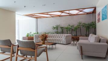 Una sala de estar moderna con un sofá seccional, una mesa de centro y dos sillones mecedores.