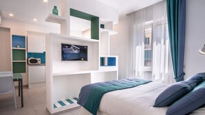 A modern bedroom with a bed, a TV, and a desk area. - Family Apartment in Sorrento Centre (Sorrento)