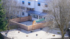 Moderni rakennus, jossa on tasakatto, useita ikkunoita ja aidattu sisäpiha.