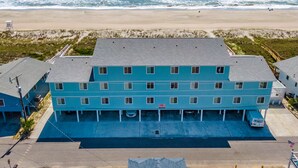 Un hotel de varios pisos con techo plano, situado cerca de una playa y vistas al océano.