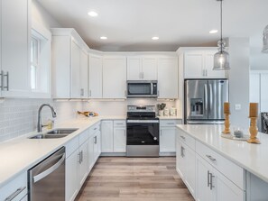 Enjoy cooking in this well-equipped kitchen with appliances, a sink, and ample countertop space.