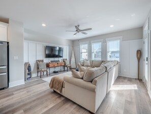 Relax in this cozy living space with a comfortable sectional sofa, flat-screen TV, and wooden coffee table.